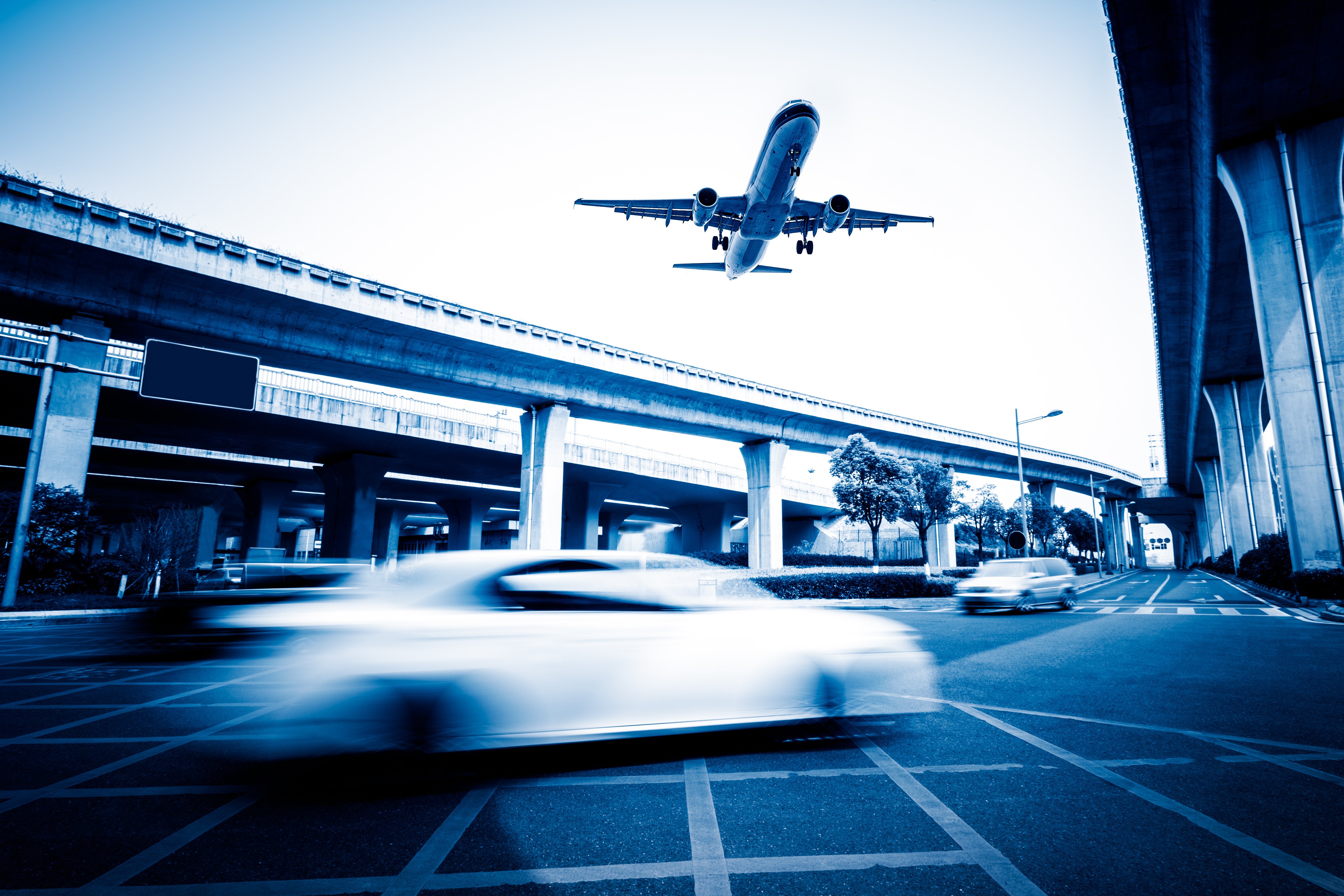 blurred-street-scene-city-with-plane-flying